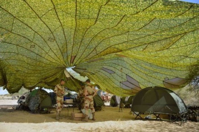 des soldats francais travaillent sous un parachute